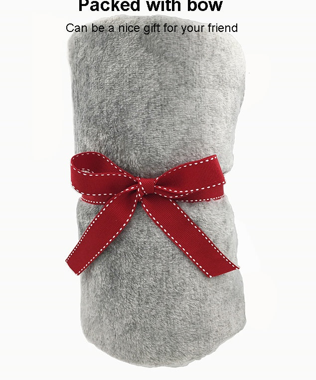 Grey flannel blanket wrapped and tied with a red gift bow