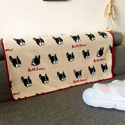 Beige dog-print blanket with repeating black dog faces and red trim