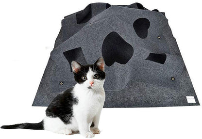 Grey square cat hole blanket with cat sitting in front of the openings
