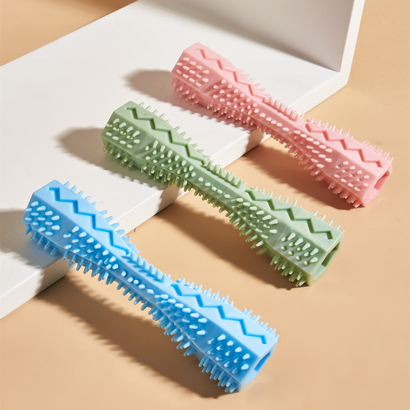Color assortment: pink, green, and blue ridged chew toys with bristle nubs