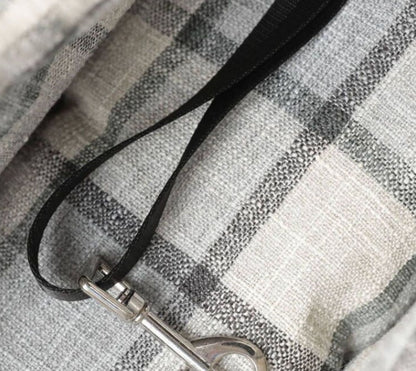 Plaid pet bag close-up: black strap with metal clasp and reinforced stitching