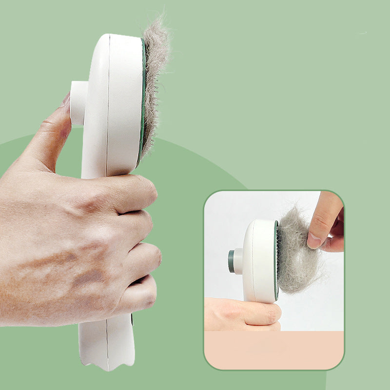 Handheld pet hair comb removing fur from brush pad, white body with dark green edge