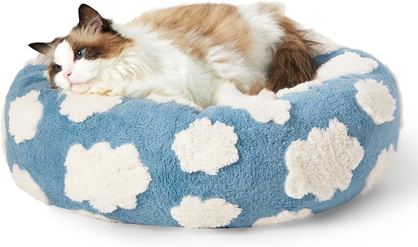 Round donut cat bed in blue with white cloud pattern and plush edges