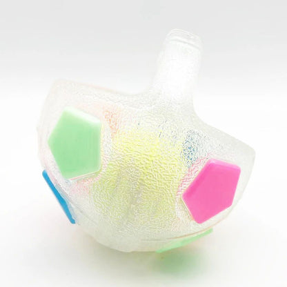 Close-up white football-shaped dog toy with green, pink and blue hex panels