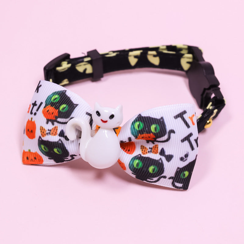 Small pet collar with safety buckle, black-and-orange pumpkin print bow, white cat charm