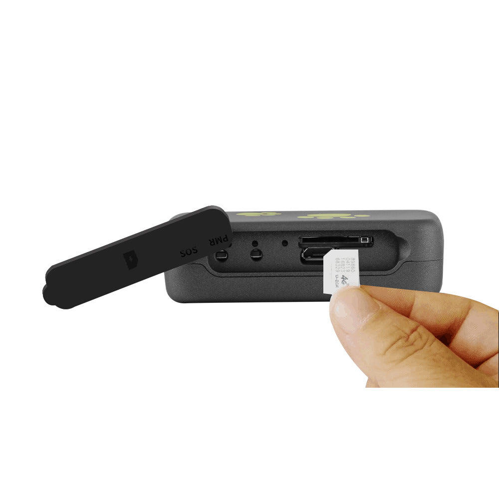 Black GPS tracker side with USB charging port shown by hand