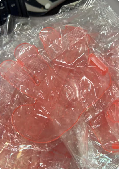 Pink pet grooming finger brush in sealed bag, with raised massage bristles