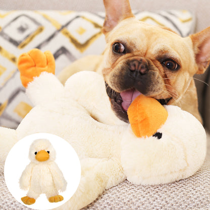 White plush duck dog toy with orange beak and feet, held by a small dog