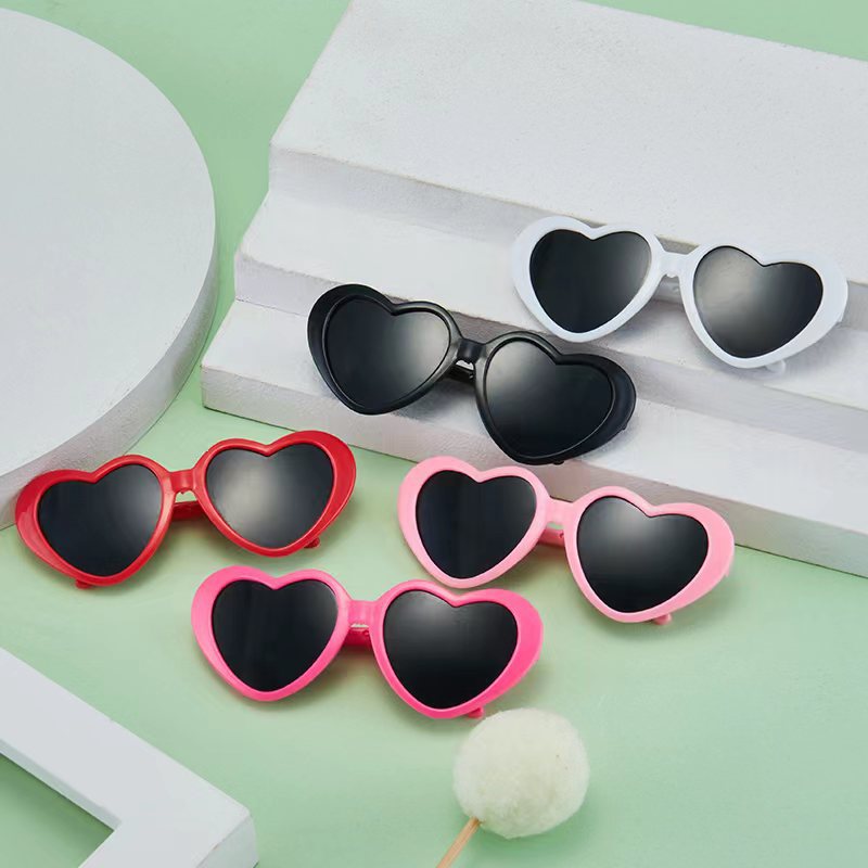 Heart-shaped pet sunglasses set with pink and black frames, dark lenses
