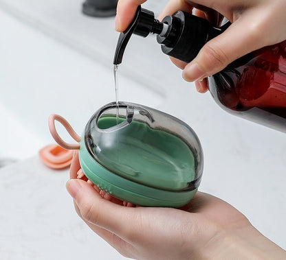 Green soap-dispensing brush, hand filling the top reservoir