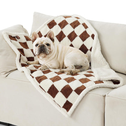 Pet waterproof blanket on a couch with brown and white check pattern, plush trim