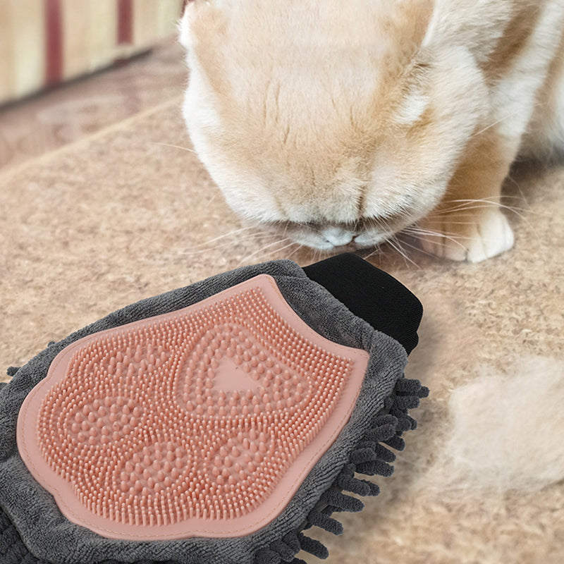 Pink silicone grooming brush glove on gray chenille for bathing, brushing, massage